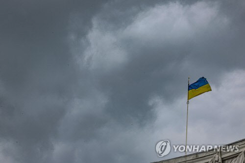 14일 우크라이나 수도 키이우 중심가에 게양된 우크라이나 국기가 흐린 하늘아래 펄럭이고 있다. <연합뉴스>